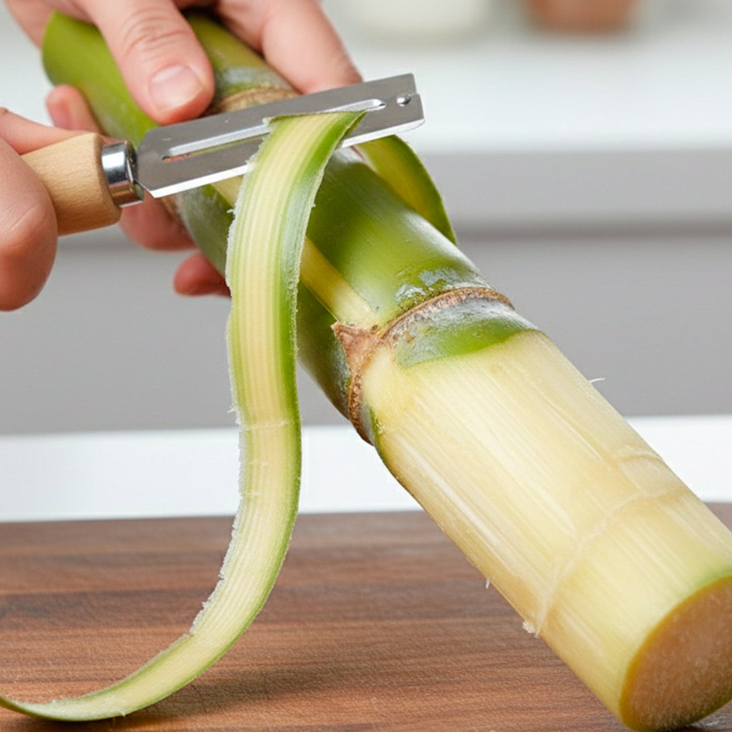 Hand holding stainless steel vegetable peeler above assorted vegetables