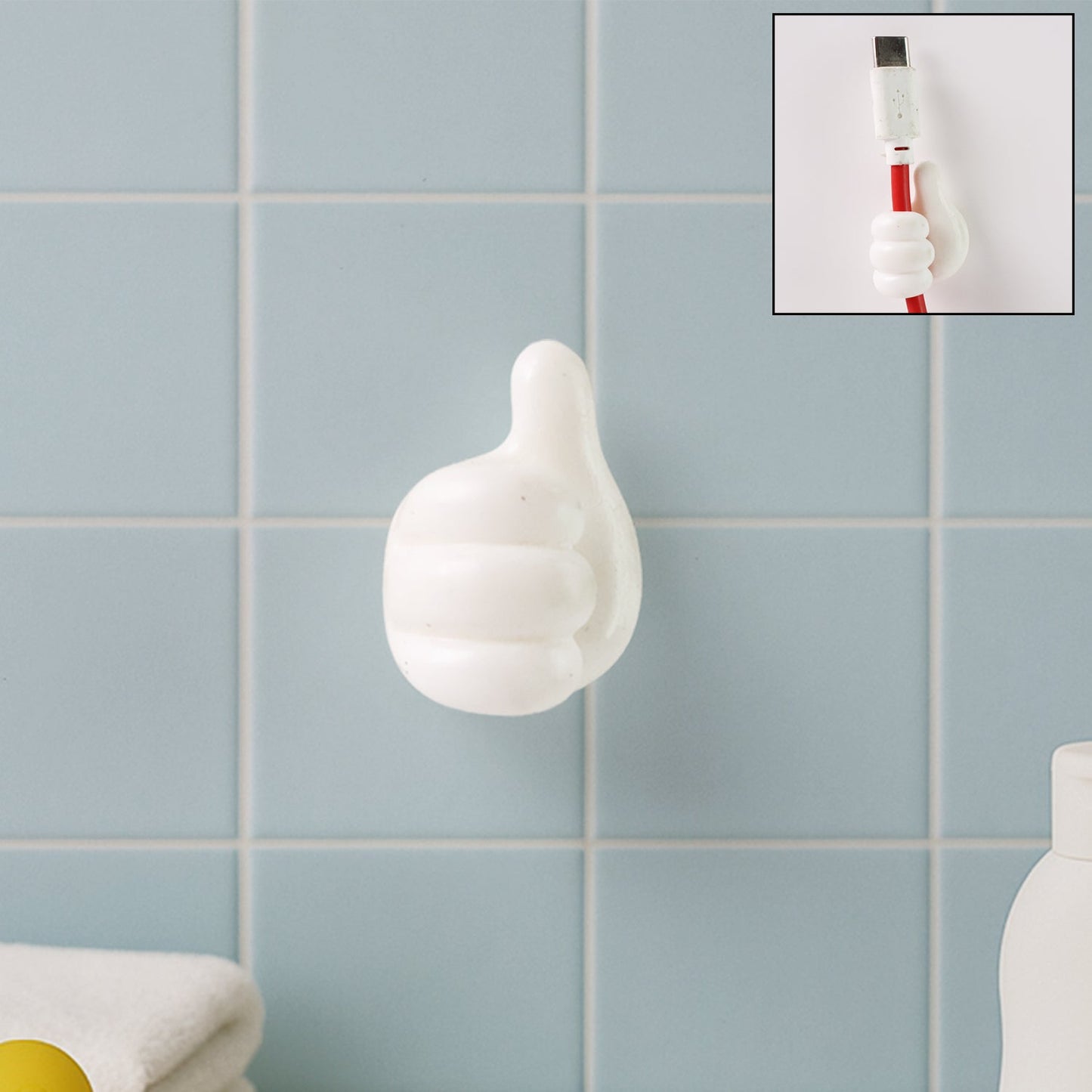 White hand-shaped wall clip holding keys and cables with thumb grip