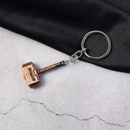 Metal Hammer Keychain with antique bronze finish on neutral background