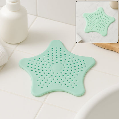 Mint green silicone star shaped sink strainer placed on bathroom sink drain