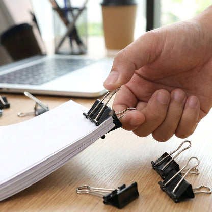Paper secured with 51 mm large binder clips for document organisation