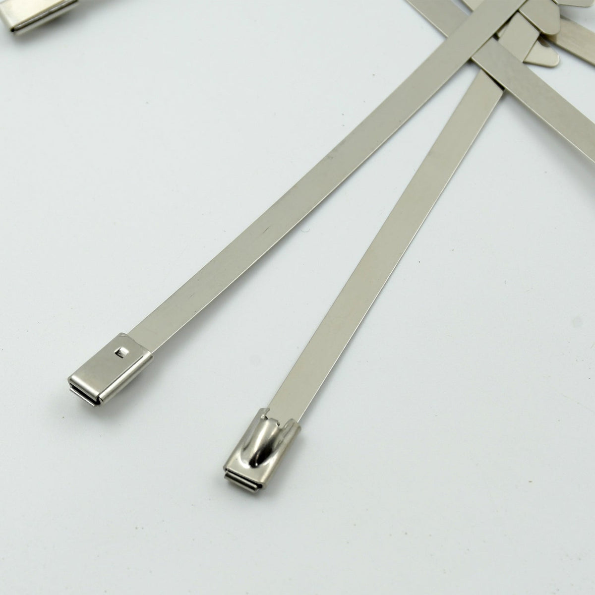 Durable stainless steel cable tie securing electrical wiring in an industrial setting.