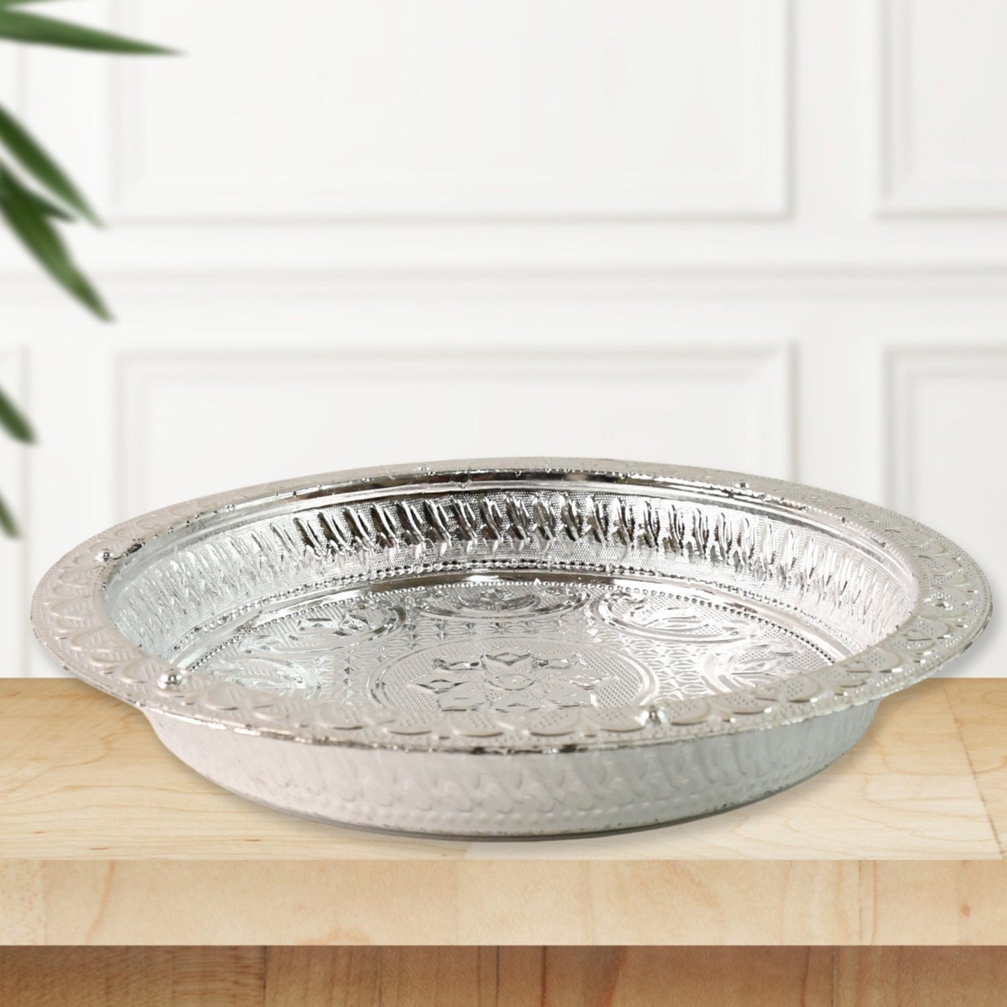 Decorative plastic pooja thali featuring silver finish and floral embossing