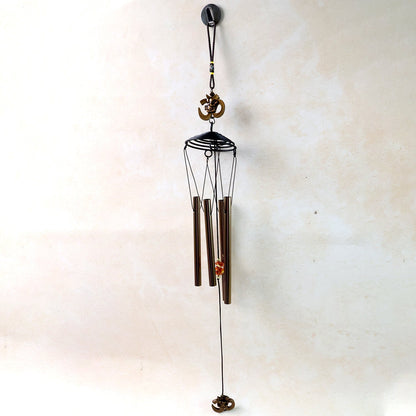 Metal Om symbol wind chime hanging on a wooden porch