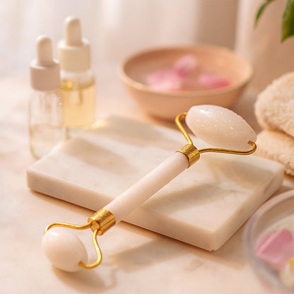 Hand holding the facial massage roller with two stone heads for gentle self-care.