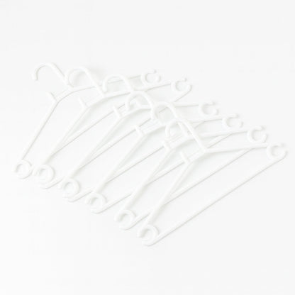 Stack of 6 white plastic clothes hangers ready for use