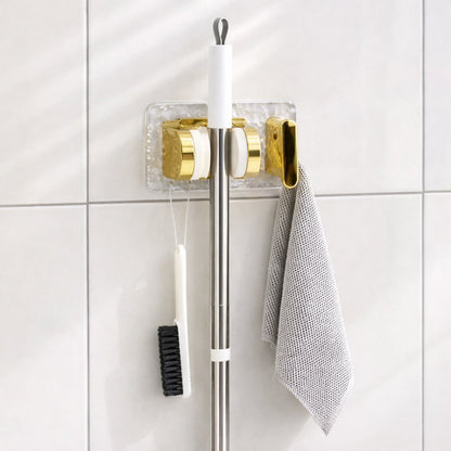 Space saving broom and mop hanger wall mounted with self adhesive base