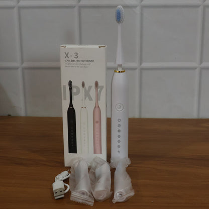 Electric toothbrush laid out with replacement brush heads for oral care