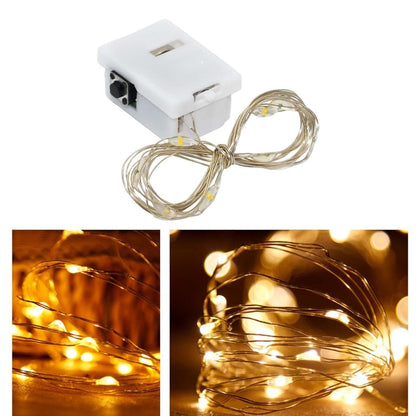 Close-up of battery powered LED fairy lights with copper wire glowing warmly