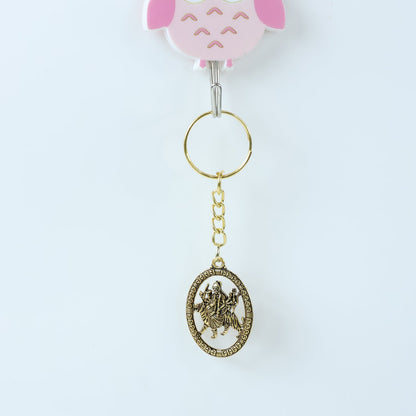 Angled view of Maa Durga Oval Frame Keychain showcasing metallic golden finish