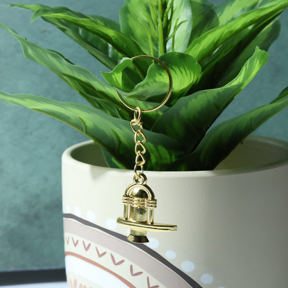 Packaged golden Shivling metal keychain ready for gifting or retail