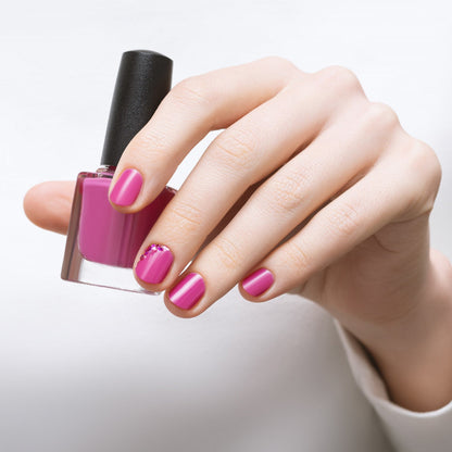 Hand holding mini matte nail polish bottle with glitter and mix colors