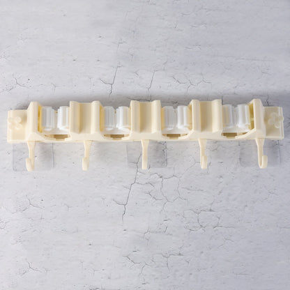 Close-up of self-adhesive broom holder rack mounted on home wall