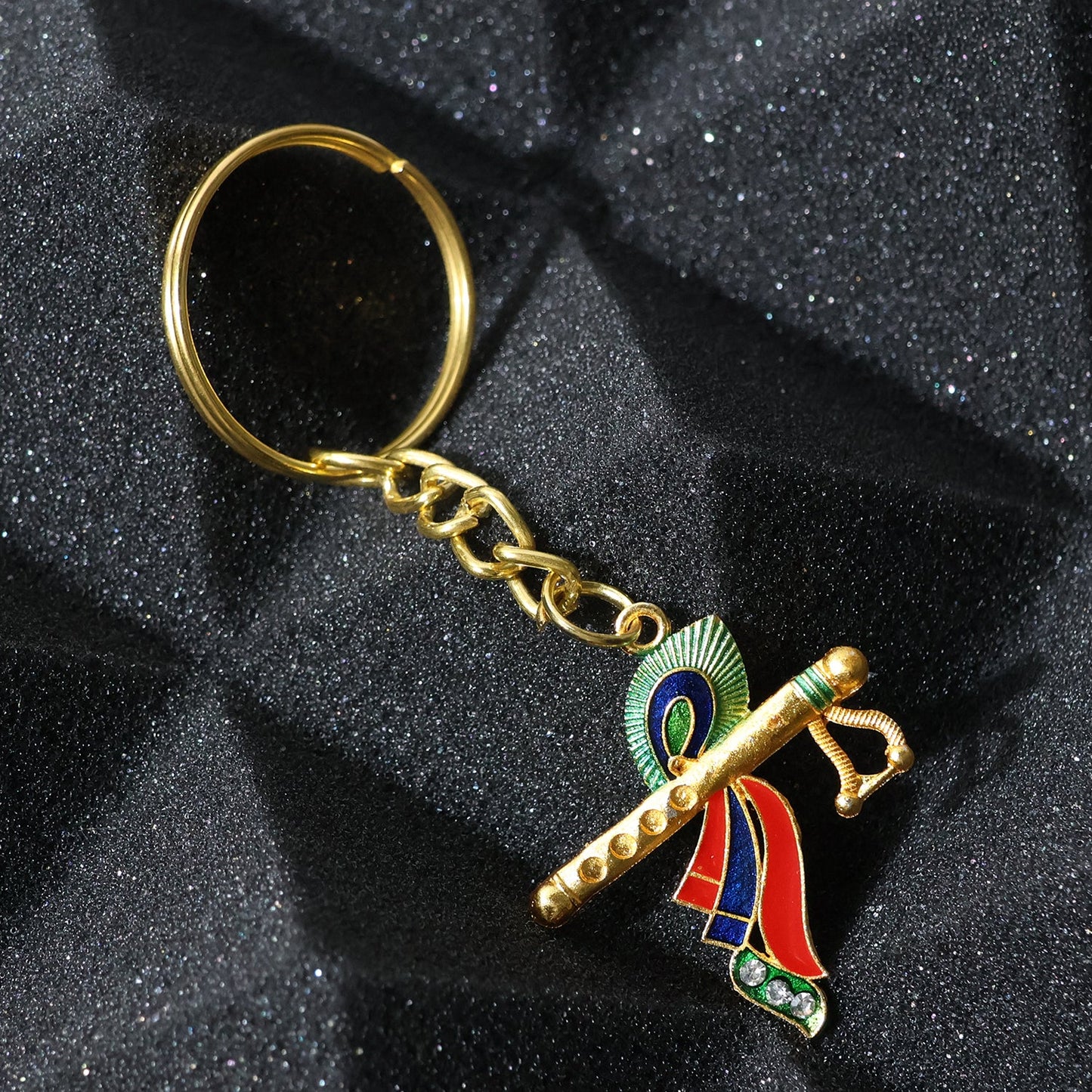 Close-up of Krishna metal keychain featuring flute and peacock feather motif