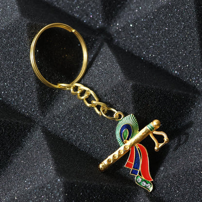 Close-up of Krishna metal keychain featuring flute and peacock feather motif