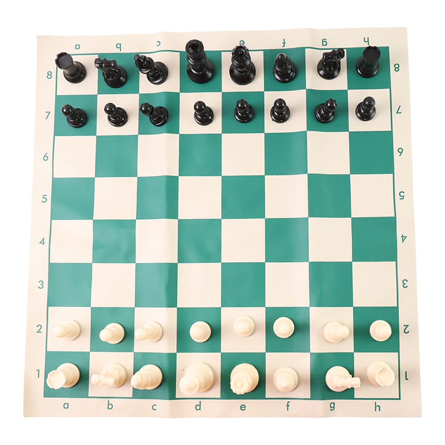 Plastic chess set pieces arranged on the roll-up green and white chess board