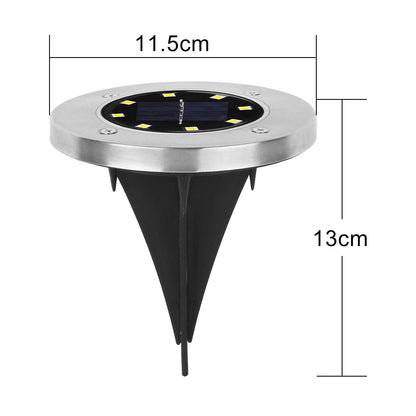 Single solar LED garden light glowing brightly at night in outdoor garden setting