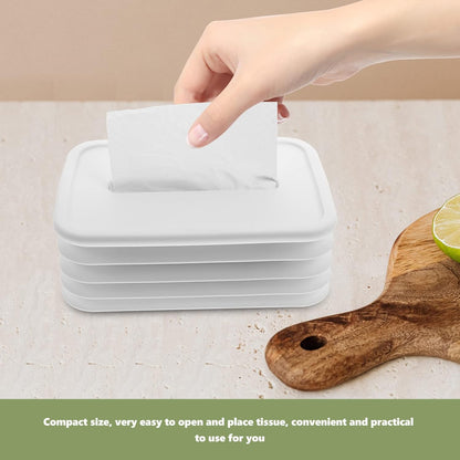 Hand pulling a tissue from the sleek silicone tissue dispenser.