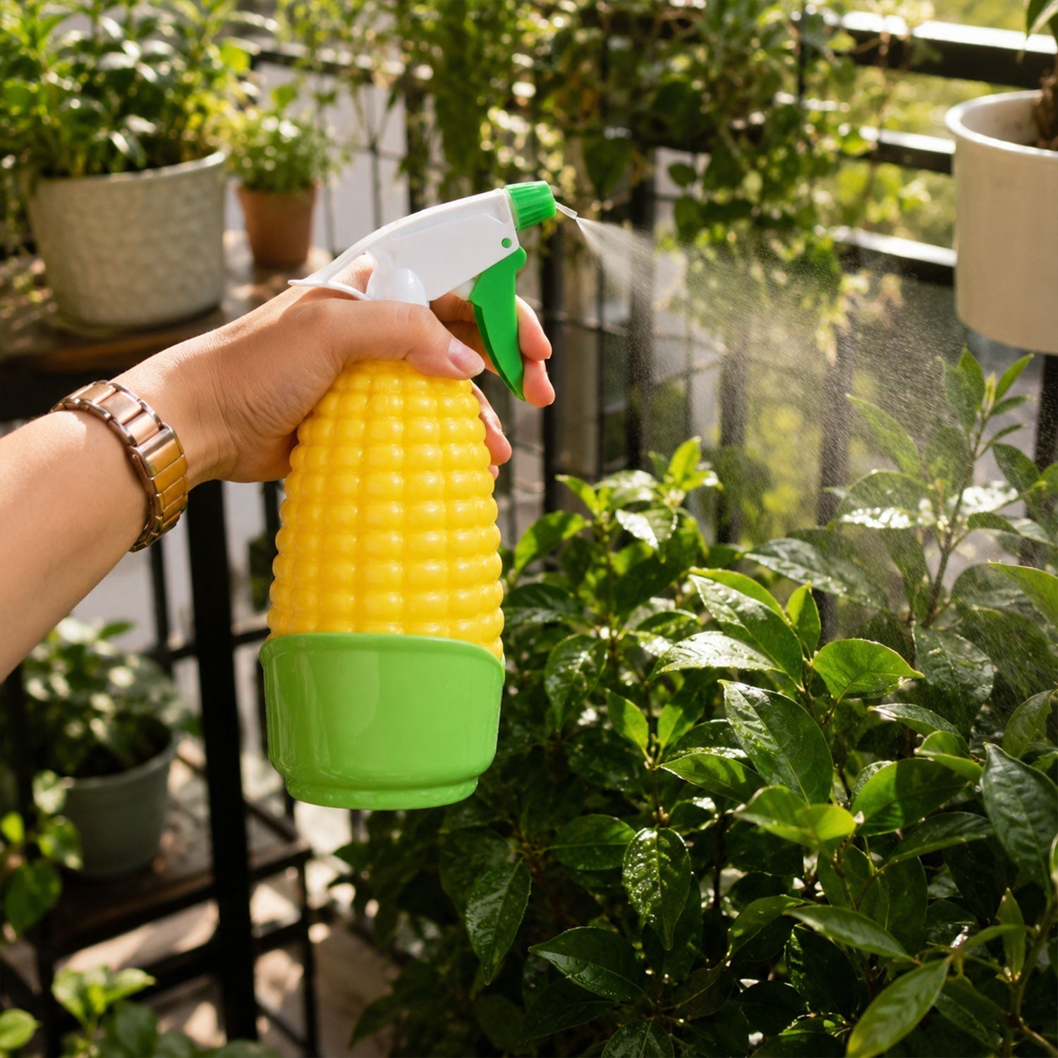 Hand using water spray for plants, demonstrating fine mist feature.