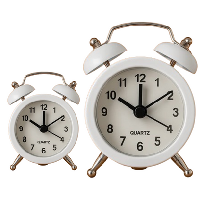 Vintage twin-bell analog alarm clock on a minimalist study desk.