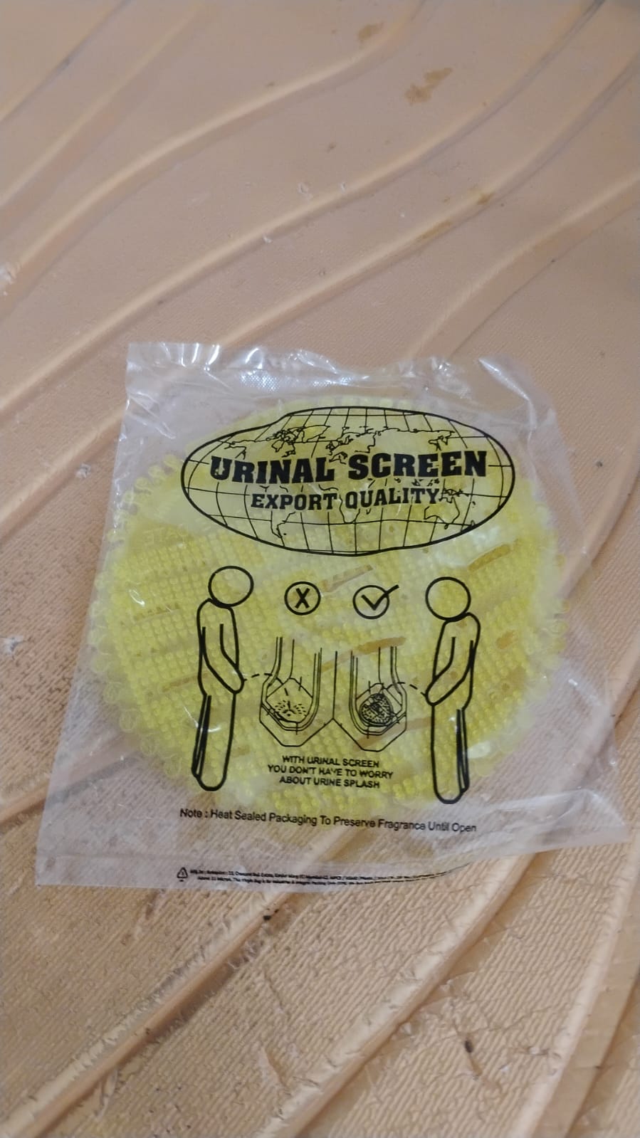 Urinal screen deodorizer mats installed in men's washroom for effective splash and odor control.