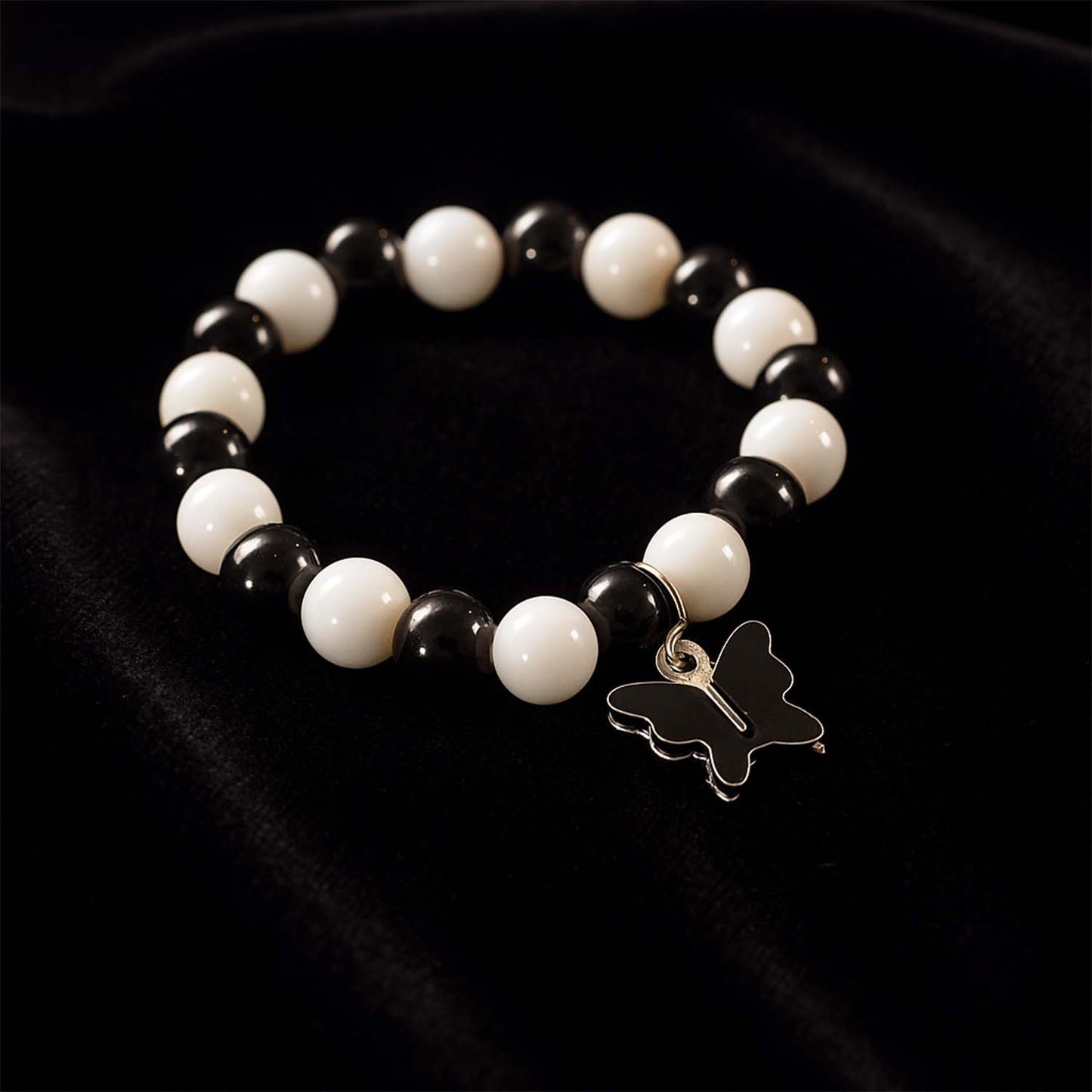 Close-up of black and white beads and cross pendant on bracelet