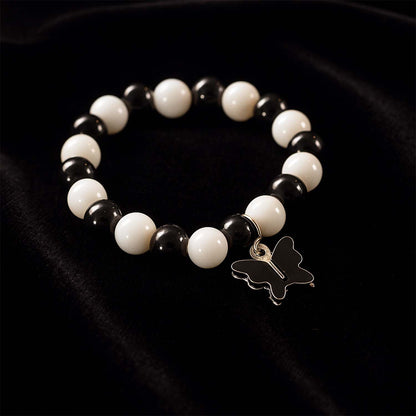 Close-up of black and white beads and cross pendant on bracelet