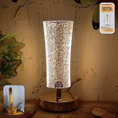 Crystal table lamp with sparkle acrylic shade and golden base illuminating softly