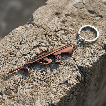 Side view of metal gun-shaped keychain accessory