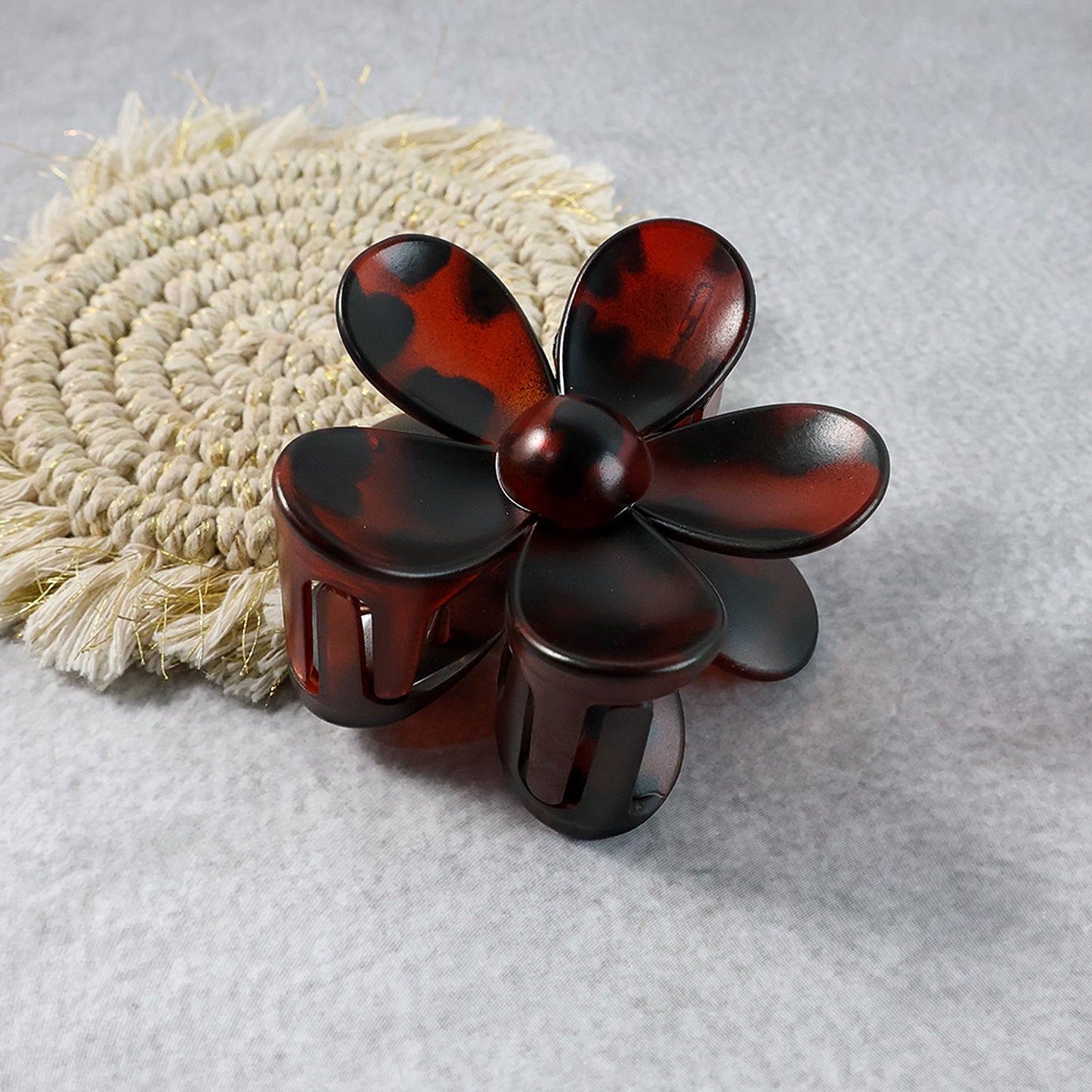 Plastic flower hair clip angled to show clasp and grip