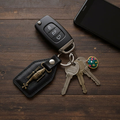 Side angle showing metal sword emblem on leather keychain