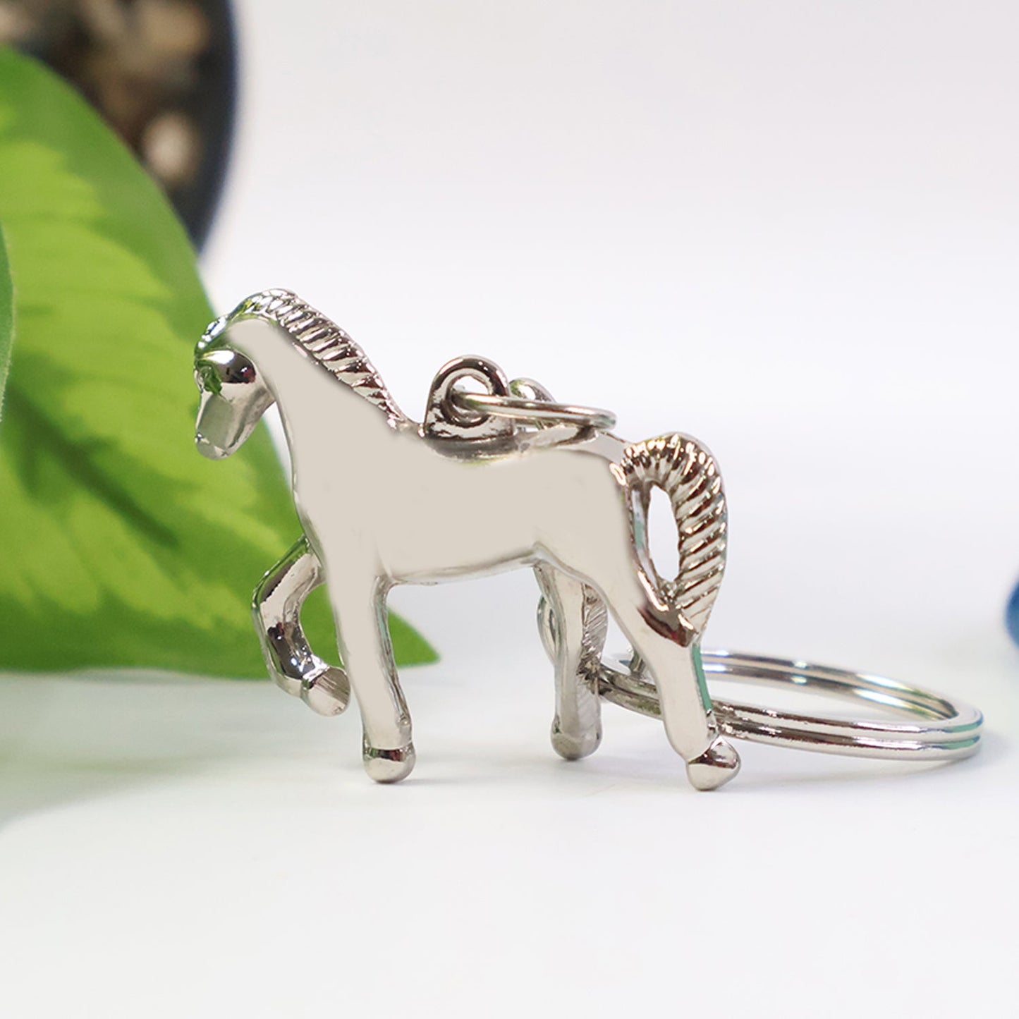 Metallic horse keychain size comparison with Indian currency note