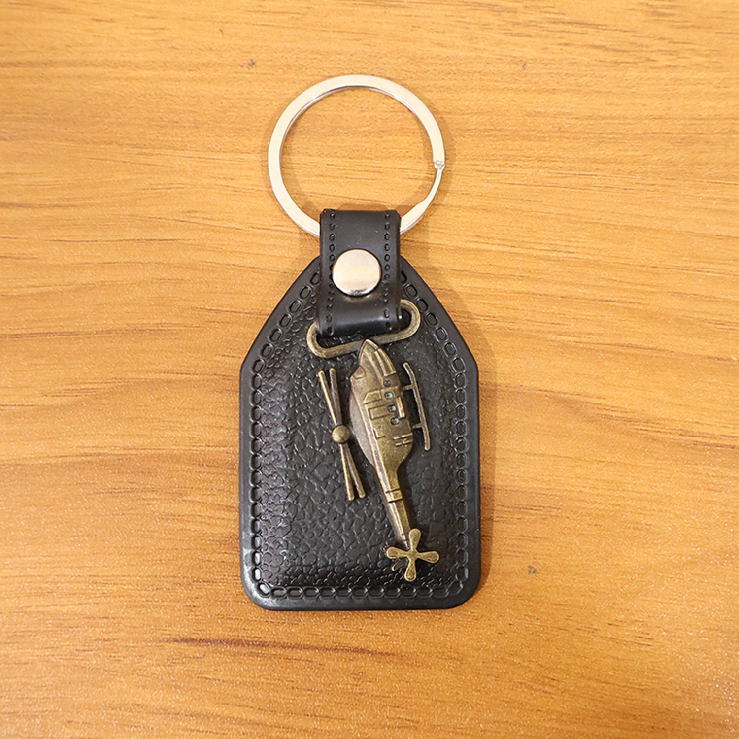 Full display of stylish leather and metal sword emblem keychain