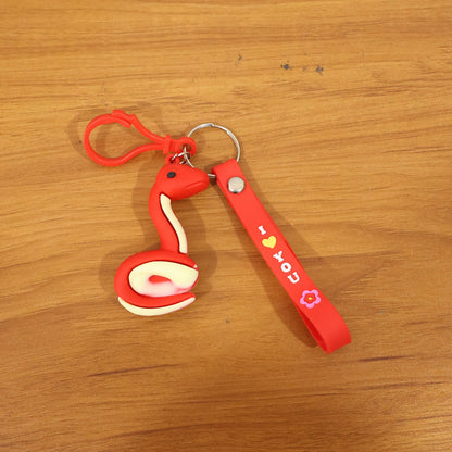 Cartoon snake keychain held in hand displaying size and clip hook
