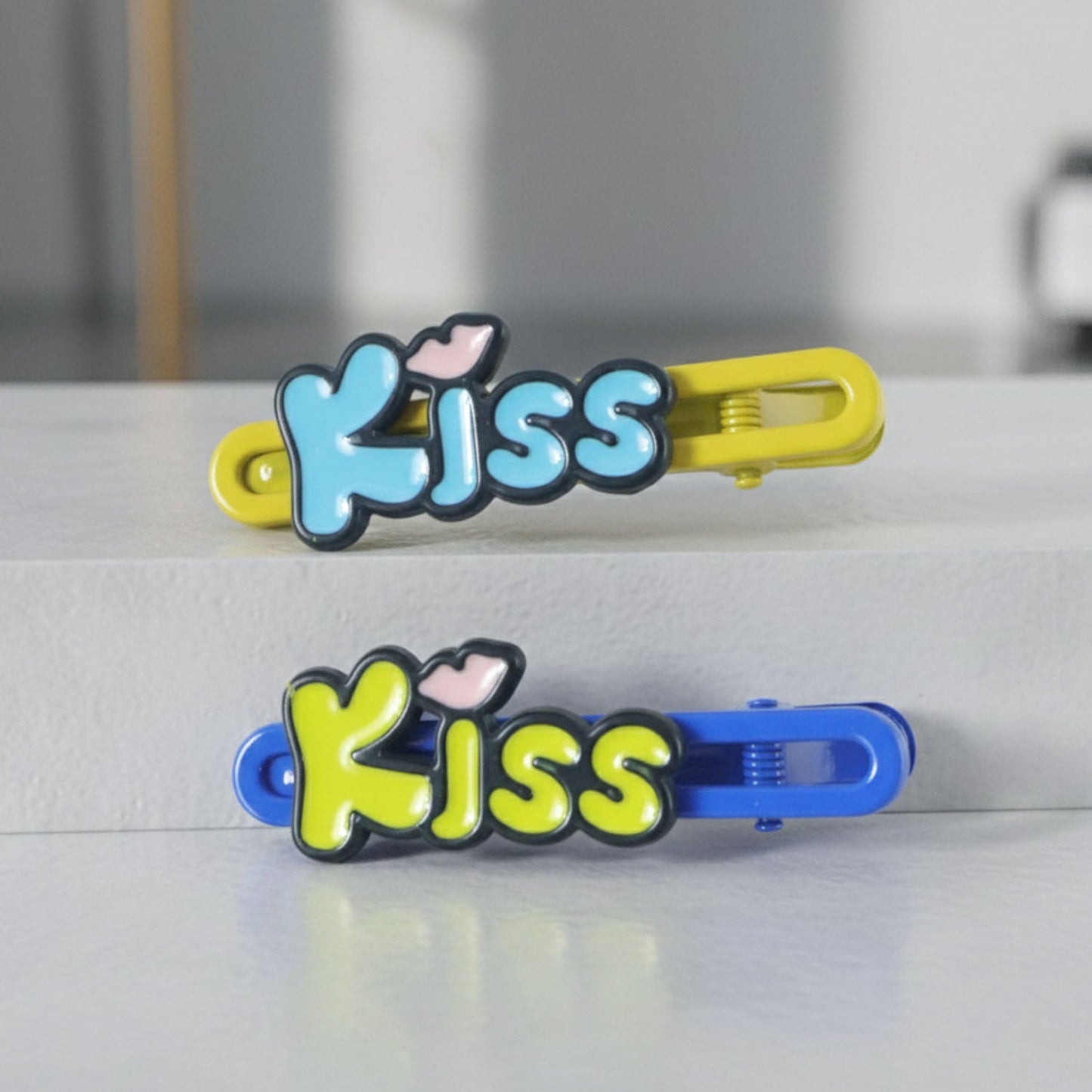 Close-up of cartoon letter Kiss hair pins in a 2-piece set