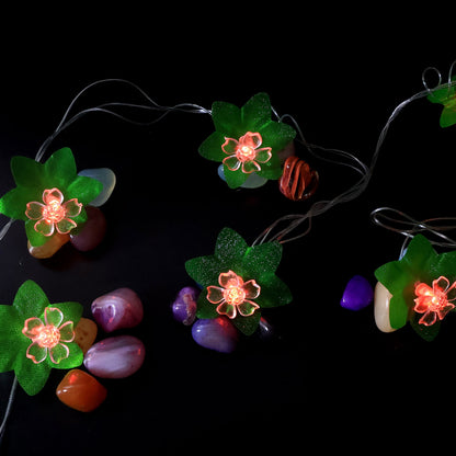 Close view of multi-color LED decorative string light showcasing leaf and flower motifs