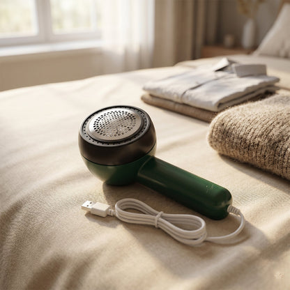 Electric lint remover in use on a sweater for fabric fuzz removal