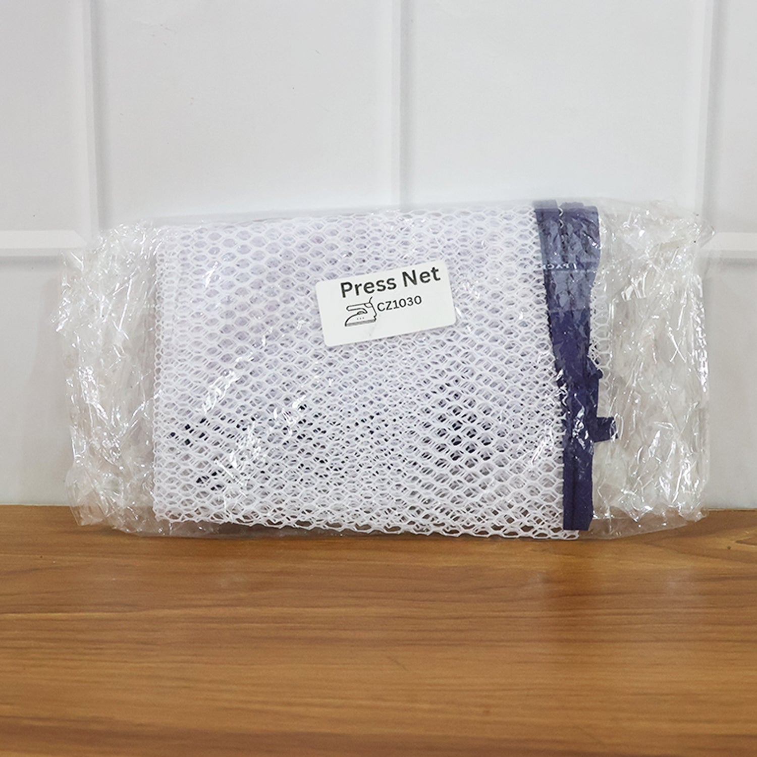 Ironing mesh press cloth safeguarding delicate patterned garment during ironing