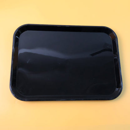 Close-up detail of smooth surface and rounded corners on black plastic serving tray