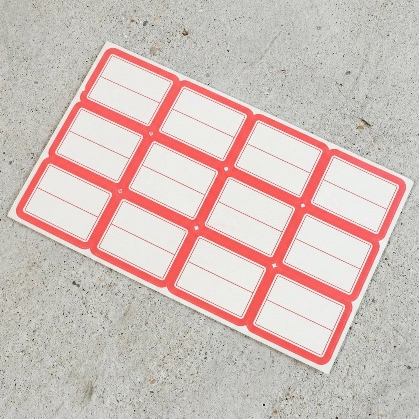 Close-up view of red and white rectangular self-adhesive label stickers