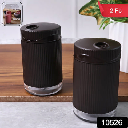 Two-piece salt and pepper shaker set with rotating lids for controlled seasoning