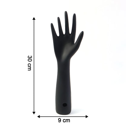 Black hand jewelry display stand placed on shelf for accessories