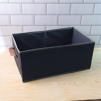 Foldable rectangular organizer bin shown neatly holding household items